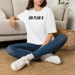 Mujer sentada en un sofá con la camiseta blanca SIN PLAN B de Idea Mala Club